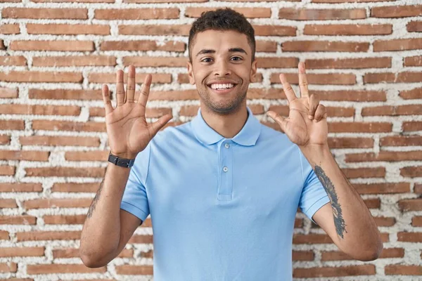 Braziliaanse Jongeman Staat Bakstenen Muur Tonen Wijzen Met Vingers Nummer — Stockfoto