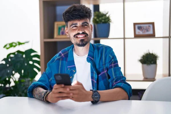 Hombre Hispano Joven Usando Teléfono Inteligente Sentado Mesa Casa — Foto de Stock