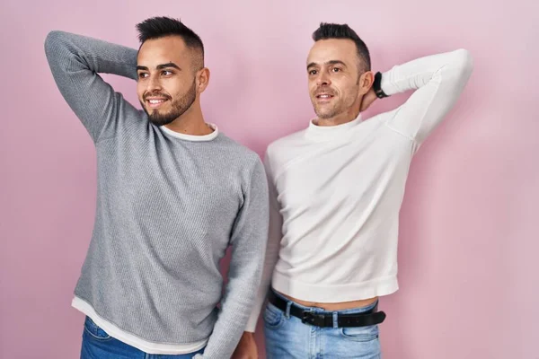 Homosexual Couple Standing Pink Background Smiling Confident Touching Hair Hand — Stockfoto