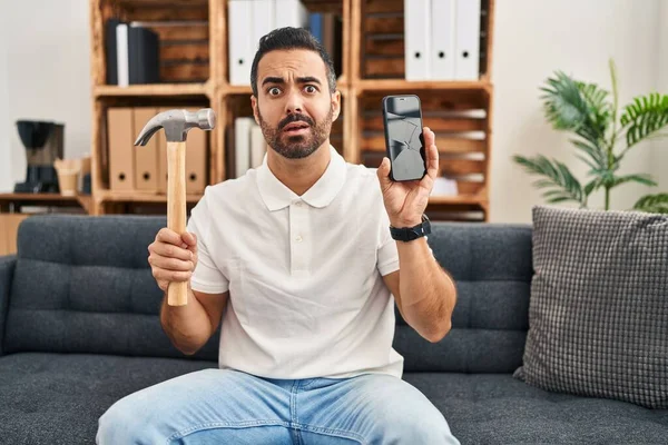 Mladý Hispánec Vousy Drží Kladivo Rozbitý Smartphone Ukazuje Prasklou Obrazovku — Stock fotografie