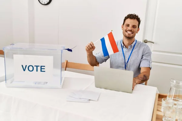 Молодий Іспаномовний Чоловік Посміхається Впевнено Тримає Голландський Прапор Працює Виборчому — стокове фото