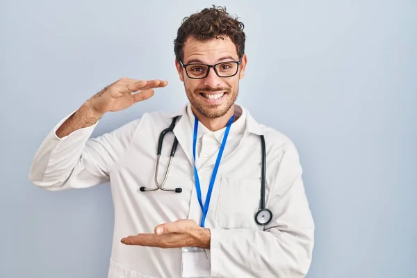 Młody Hiszpan Noszący Mundur Lekarza Stetoskop Gestykulujący Rękami Pokazującymi Duży — Zdjęcie stockowe