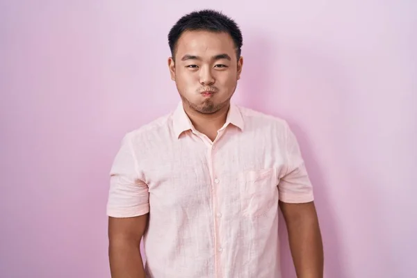 Китайский Молодой Человек Стоящий Розовом Фоне Пыхтя Щеками Смешным Лицом — стоковое фото