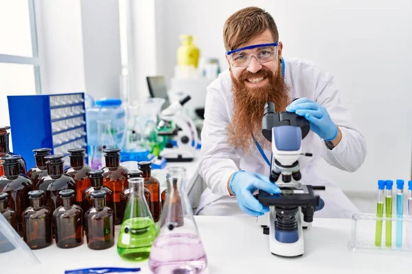 Ung Rödhårig Man Klädd Forskaruniform Med Mikroskop Laboratoriet — Stockfoto