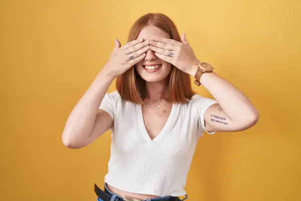 Young Redhead Woman Standing Yellow Background Covering Eyes Hands Smiling — Stock Photo, Image