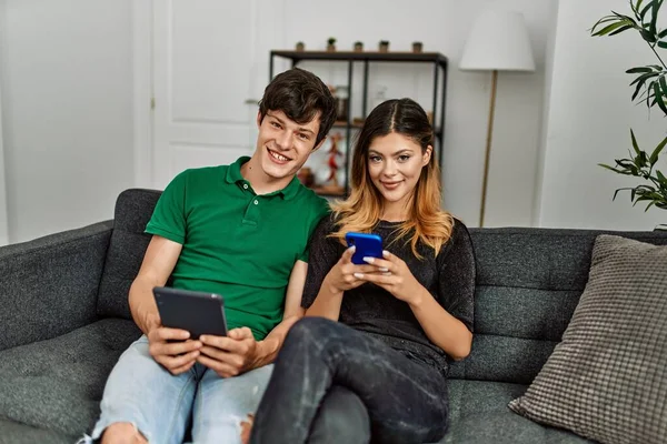 Jovem Casal Caucasiano Sorrindo Feliz Usando Touchpad Smartphone Casa — Fotografia de Stock