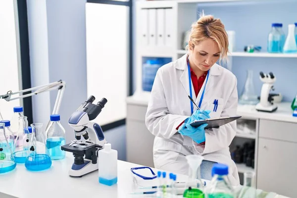 Joven Mujer Rubia Científica Escribiendo Documento Laboratorio —  Fotos de Stock