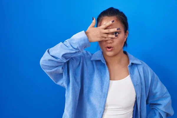 Asian Young Woman Standing Blue Background Peeking Shock Covering Face — Foto Stock