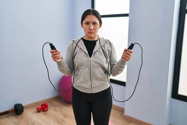 Young Latin Woman Jumping Skipping Rope Skeptic Nervous Frowning Upset — Stockfoto