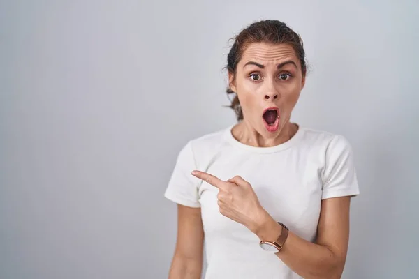 Beautiful Brunette Woman Standing Isolated Background Surprised Pointing Finger Side — Stock Photo, Image