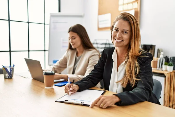 Mother and daughter business workers smiling confident working at office