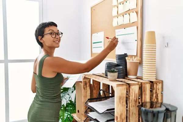 Young Hispanic Woman Smiling Confident Writing Corkboard Office — Stockfoto
