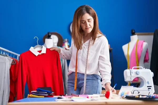 Jovem Alfaiate Segurando Camisa Escrevendo Papel Estúdio Costura — Fotografia de Stock