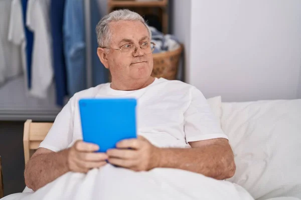 Μεσήλικας Γκριζομάλλης Άντρας Που Χρησιμοποιεί Touchpad Κάθεται Στο Κρεβάτι Στο — Φωτογραφία Αρχείου