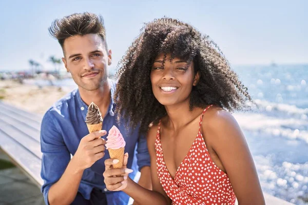 Man and woman couple smiling confident using smartphone at seaside