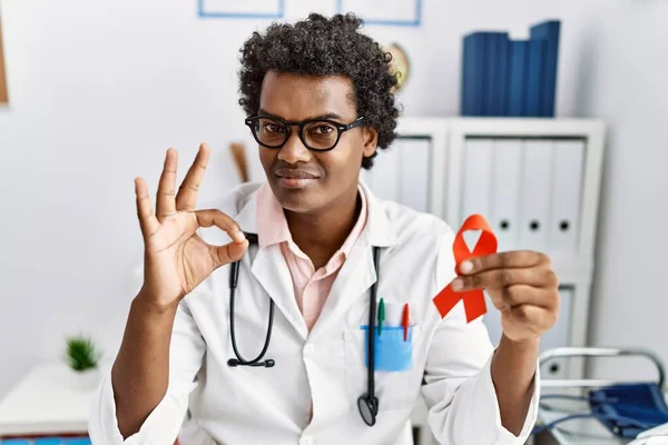 African Doctor Man Holding Support Red Ribbon Doing Sign Fingers — Fotografia de Stock