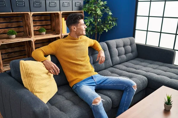 stock image Young hispanic man smiling confident sitting on sofa at home