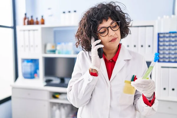 Junge Schöne Hispanische Wissenschaftlerin Spricht Auf Smartphone Mit Reagenzglas Auf — Stockfoto