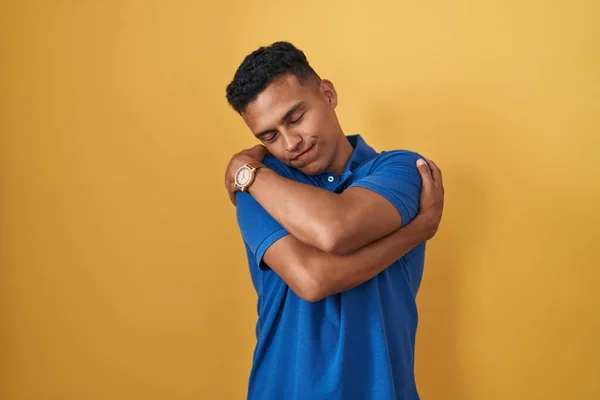 Young Hispanic Man Standing Yellow Background Hugging Oneself Happy Positive — Stock Photo, Image