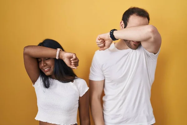 Interracial Couple Standing Yellow Background Covering Eyes Arm Smiling Cheerful — Foto Stock