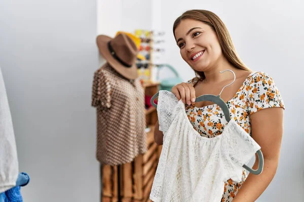 年轻的惊慌失措的女人带着自信的笑容在服装店购物 — 图库照片