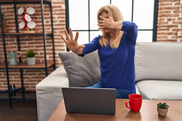 Middle Age Blonde Woman Using Computer Laptop Home Covering Eyes — Fotografia de Stock