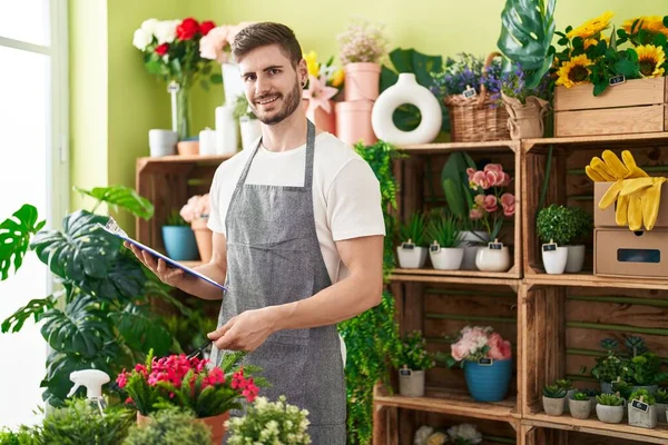 Çiçekçide kendinden emin gülümseyen beyaz bir adam.