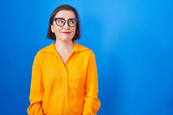 Mulher Hispânica Meia Idade Usando Óculos Sobre Fundo Azul Sorrindo — Fotografia de Stock