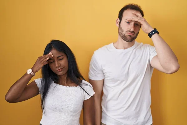 Interracial Couple Standing Yellow Background Worried Stressed Problem Hand Forehead — Foto de Stock