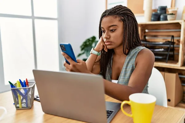 使用智能手机在办公室工作的年轻的非洲裔美国女商人 — 图库照片