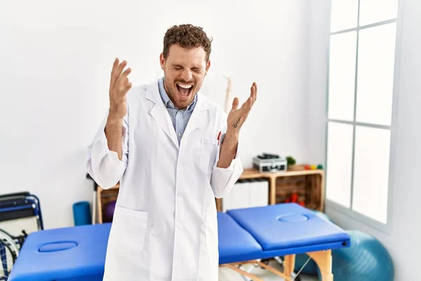 Handsome Young Man Working Pain Recovery Clinic Celebrating Mad Crazy — Stock Photo, Image