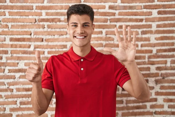 Jovem Hispânico Homem Sobre Tijolos Parede Mostrando Apontando Para Cima — Fotografia de Stock