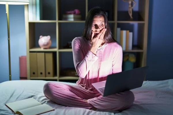 Young Hispanic Woman Using Computer Laptop Bed Shocked Covering Mouth —  Fotos de Stock