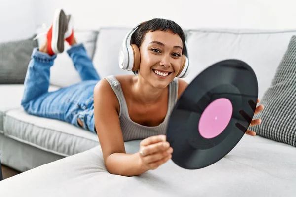 Joven Mujer Hispana Escuchando Música Sosteniendo Disco Vinilo Tumbado Sofá — Foto de Stock