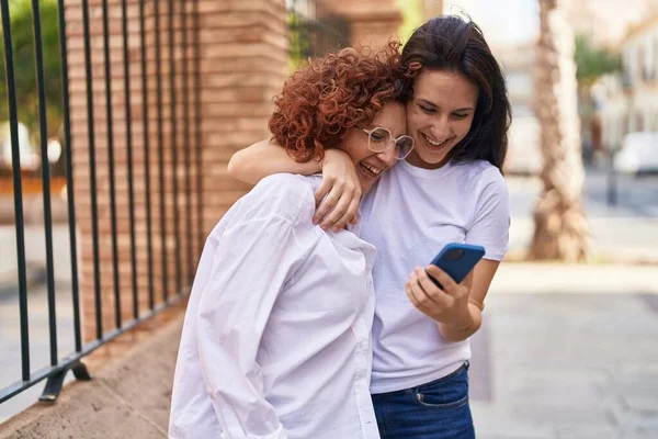 Dvě Ženy Matka Dcera Objímání Navzájem Pomocí Smartphone Ulici — Stock fotografie
