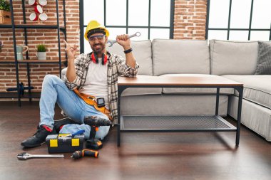 Sakallı genç İspanyol adam, hareket servisi üzerinde çalışıyor. Gülümsüyor, mutlu bir şekilde elini ve parmağını yana uzatıyordu. 