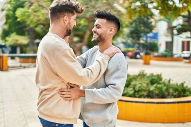 Young couple smiling confident hugging each other at park