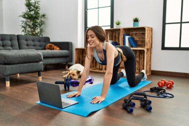 Evde esneme kursu aldığından emin bir şekilde gülümseyen genç İspanyol kadın.