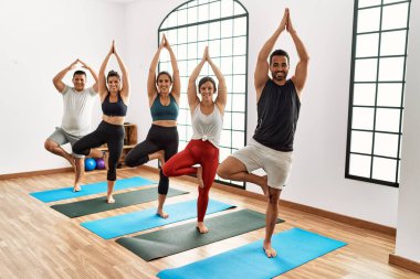 Spor merkezinde mutlu bir yoga eğitimi veren bir grup genç..