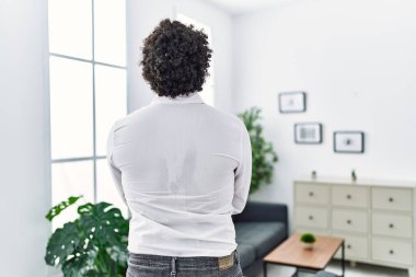 African psychologist man at consultation office standing backwards looking away with crossed arms 