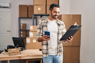 Genç bir İspanyol iş adamı ofisteki akıllı telefon okuma belgesini kullanıyor.