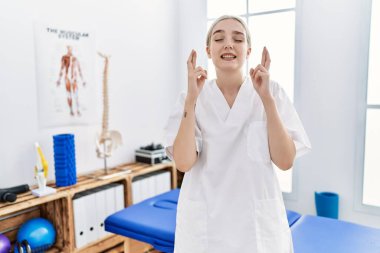 Ağrı giderme kliniğinde çalışan beyaz bir kadın umut ve gözlerin kapalı gülümseyerek bana işaret etti. Şans ve batıl inançlar. 