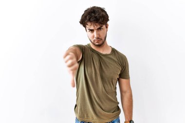 İzole edilmiş beyaz arka planda duran İspanyol adam mutsuz ve kızgın görünüyor. Reddedilmiş ve olumsuz bir hareket sergiliyor. kötü ifade. 