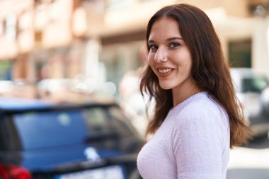 Sokakta kendinden emin gülümseyen genç bir kadın