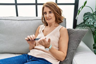 Orta yaşlı İspanyol kadın evde çivili kireç kullandığından emin gülümsüyor.