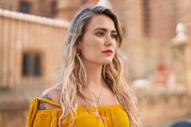 Sokakta duran rahat yüzlü genç kadın.