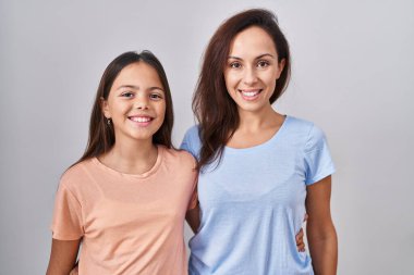 Young mother and daughter standing over white background with a happy and cool smile on face. lucky person. 