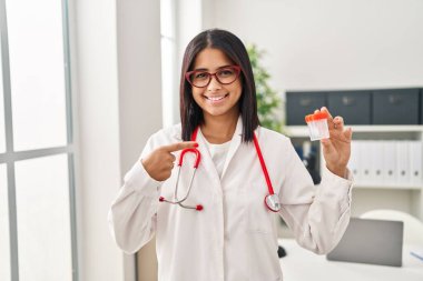 Genç İspanyol doktor elinde numune kabıyla mutlu bir şekilde gülümsüyor. 