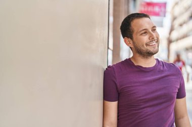Young man smiling confident looking to the side at street