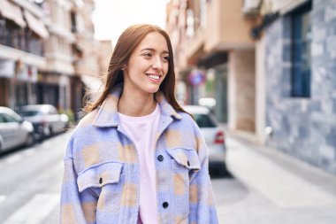 Young beautiful hispanic woman smiling confident looking to the side at street